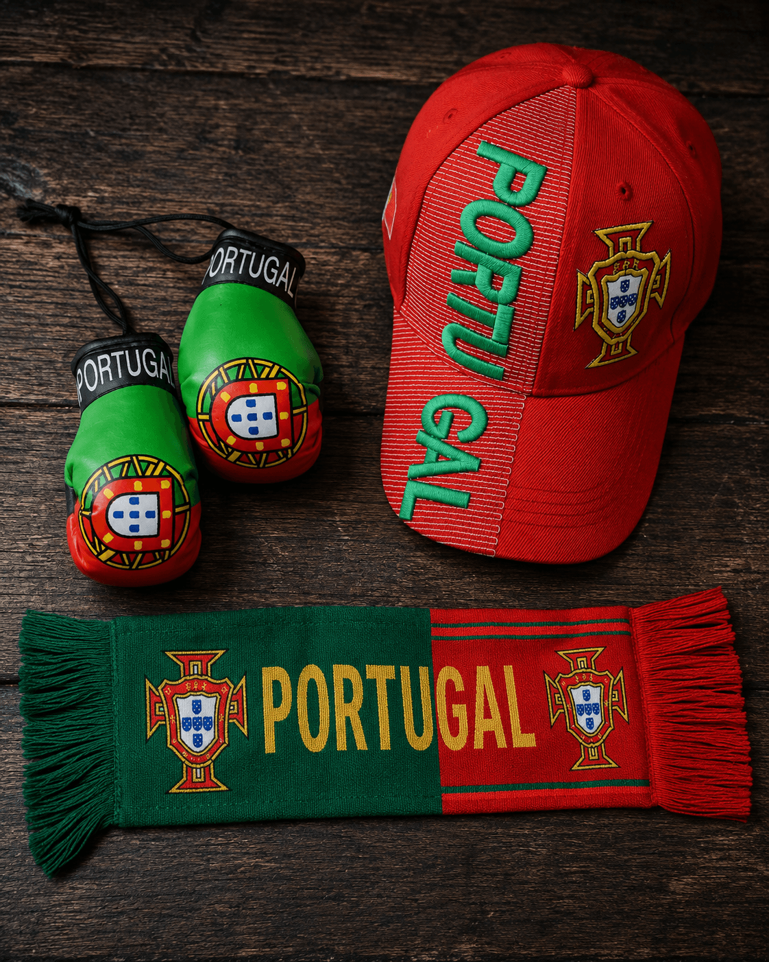 Portugal fan gear flat lay with boxing gloves, cap and scarf on wood surface