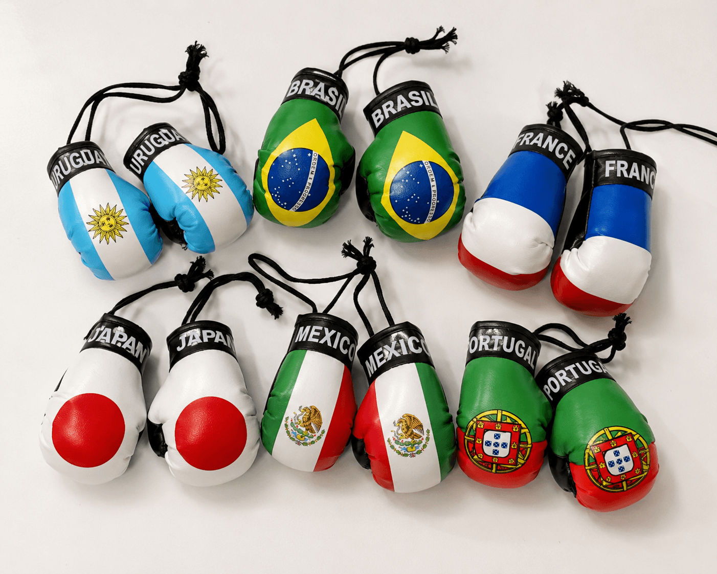 Six pairs of mini souvenir boxing gloves with national flags flat lay